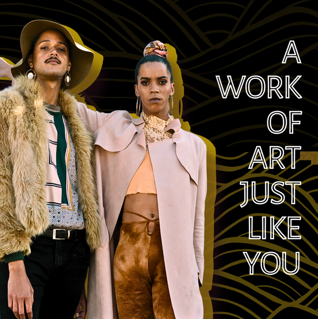 Two stylish individuals stand confidently against a dark patterned backdrop. One wears a tan fur jacket, geometric print blouse, and wide-brimmed hat; the other wears a pale pink coat over a lace top and high-waisted brown pants. The text beside them reads “A work of art just like you."
