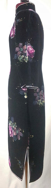Side view of a 1950s black velvet cheongsam qipao dress with a mandarin collar, contrasting piping and hand-painted pink floral design displayed on a mannequin 