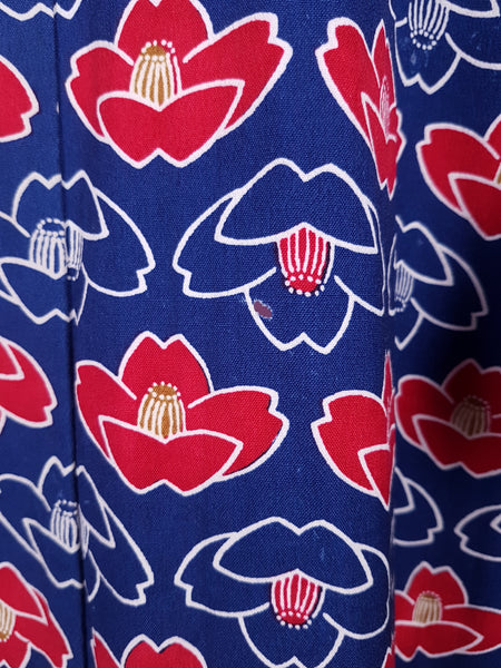 Close up of small hole, largest one is on back panel and about 1cm in size. Vintage hand-stitched full-length Japanese cotton kimono displayed on a mannequin, with a bold blue, red and white lotus flower print 