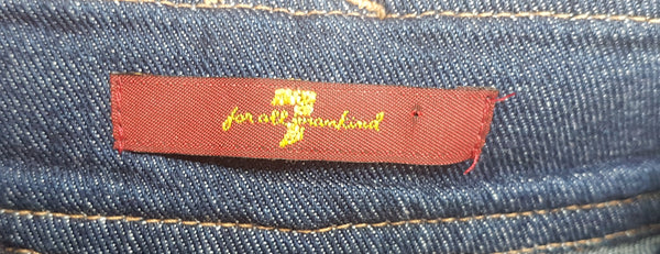 Close-up of the red-and-gold 7 For All Mankind label attached on the inner waistband on 7 For All Mankind indigo jeans