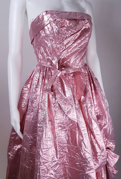 Side view of pink lamé gown showing fitted waist and gathered bustle-style skirt