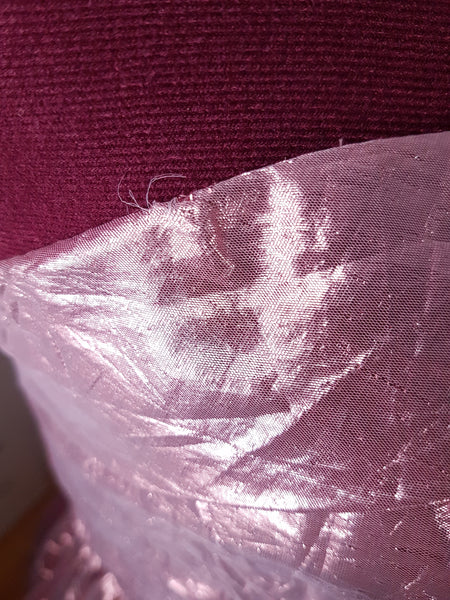 Close-up of wear along the upper edge of the metallic pink strapless bodice