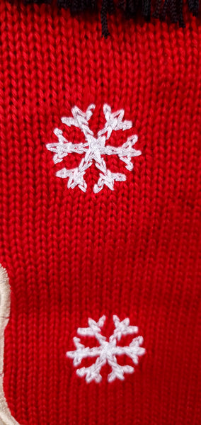 Close-up of embroidered white snowflakes on the red knitted sweater dress