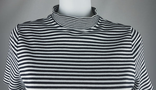 Close-up of the striped mock neckline and upper front of an Alia black and white knit top.