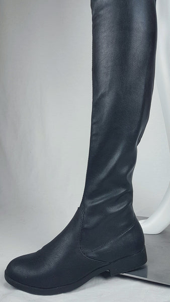 Black vegan leather over-the-knee boots with a smooth texture and a slight sheen, featuring a partial side zip closure and an almond-shaped toe displayed on a mannequin - side view