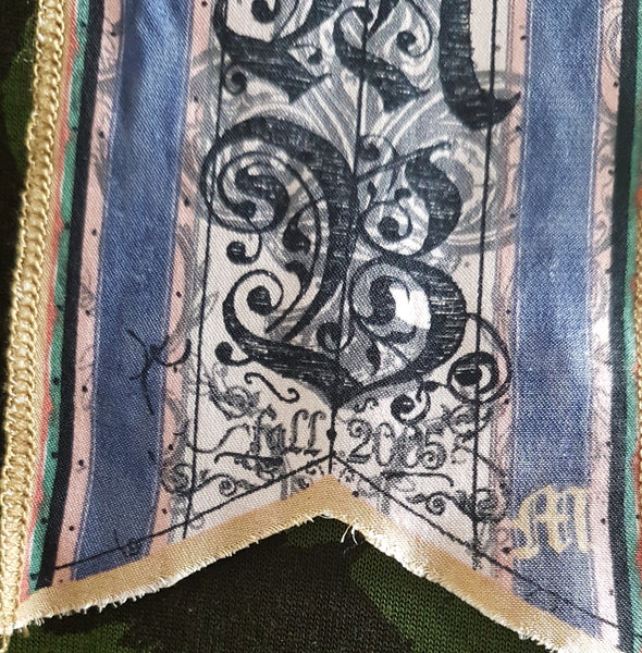 Label detail of Green and black patterned “LOVE” T-shirt top from Gwen Stefani’s Fall 2005 L.A.M.B. collection, with an ornate black chest motif.