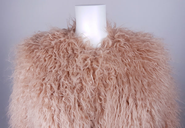 Close-up of collarless round neckline and shaggy dusty rose faux fur