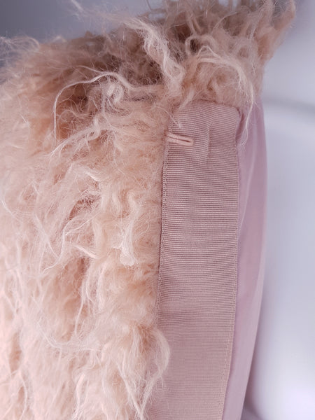 Interior of pink faux-fur jacket showing satin lining and concealed hook fastening