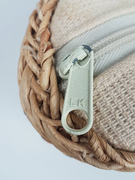 Close-up of the silver-tone zipper pull marked LKK beside the braided top edge