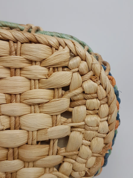 Close-up of the tightly woven natural base and rounded corner of the tote