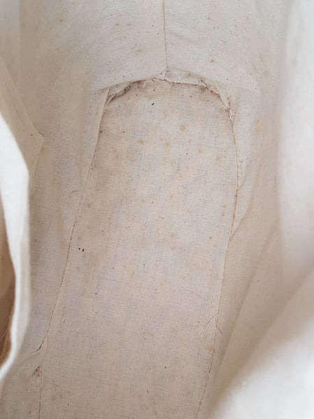 Close-up of mottled marks and spotting on the cream fabric lining