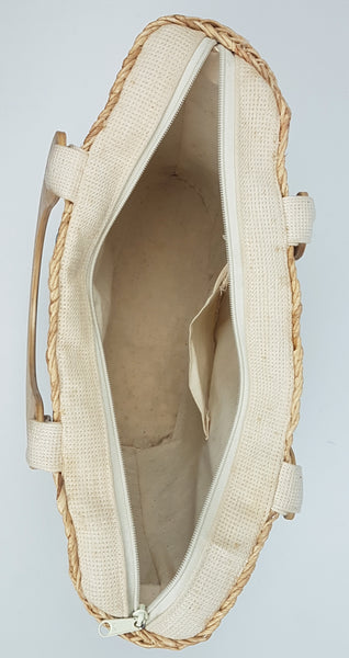 Open interior of the woven tote showing the cream fabric lining and slip pocket