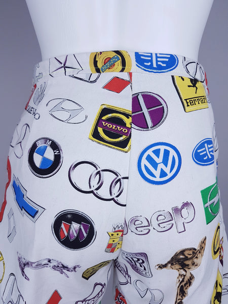 Back view showing the uninterrupted automotive-emblem print and shaping through the high waist
