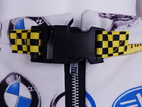 Close-up of the black side-release buckle and yellow-and-black checkerboard webbing belt