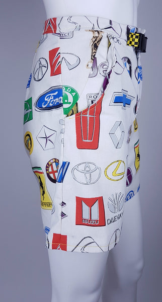 Side view of high-waisted automotive-print shorts with an exposed metal zipper and checkerboard buckle belt