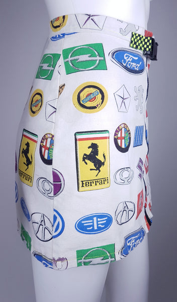 Three quarter view of an automotive-logo mini skirt with a neon checkerboard belt