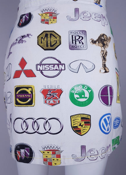 Back view of the high-waisted mini skirt with manufacturer names and emblems across the white fabric