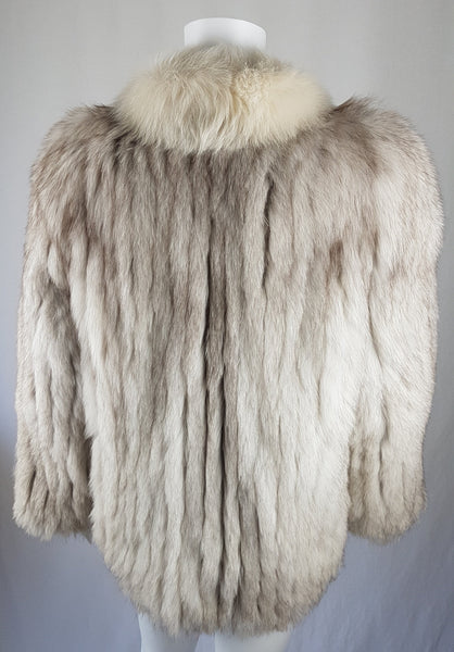 Back view Saga Fox Pale blue fox fur jacket with long sleeves, a plush collar, and natural silver grey markings on a mannequin