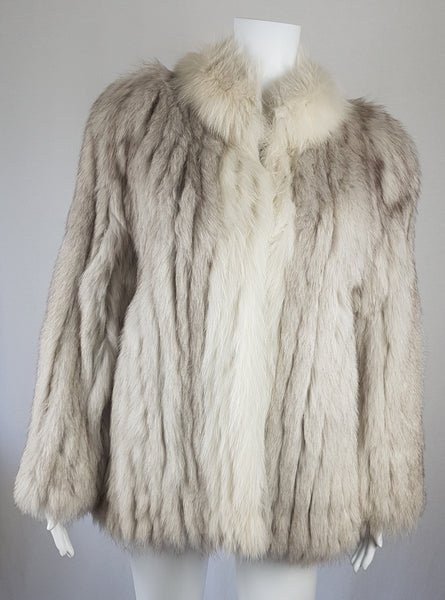 Saga Fox Pale blue fox fur jacket with long sleeves, a plush collar, and natural silver grey markings on a mannequin