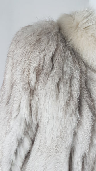 Shoulder view of Saga Fox Pale blue fox fur jacket with long sleeves, a plush collar, and natural silver grey markings on a mannequin