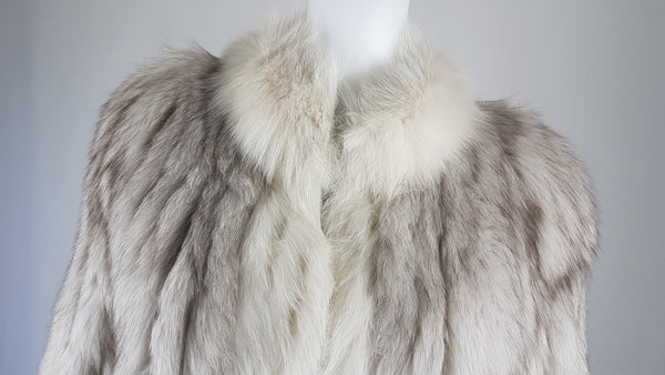 Saga Fox Pale blue fox fur jacket with long sleeves, a plush collar, and natural silver grey markings on a mannequin