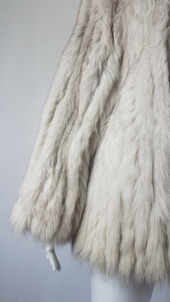 Sleeve view of Saga Fox Pale blue fox fur jacket with long sleeves, a plush collar, and natural silver grey markings on a mannequin