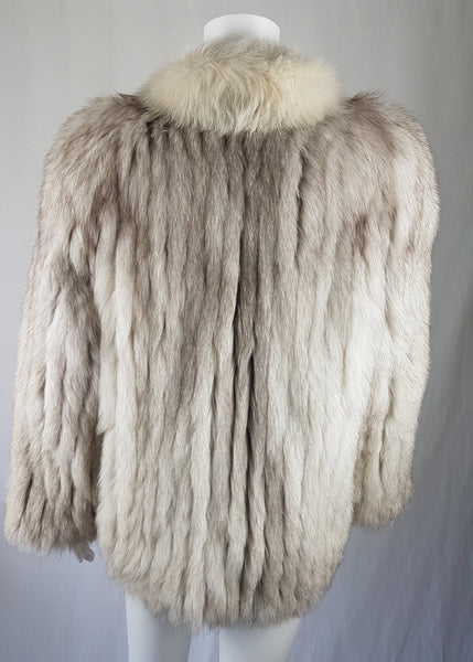 Back view of Saga Fox Pale blue fox fur jacket with long sleeves, a plush collar, and natural silver grey markings on a mannequin