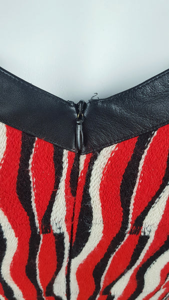 Close-up zipper view of a modern Tocca woven dress, showing the black-trimmed neckline and centre-back zipper.