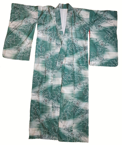 Vintage 1940s Japanese green silk kimono laid flat with its wide sleeves extended, showing the full floral pattern and open-front construction.