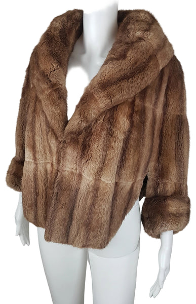 Three-quarter front view of a vintage 1950s Hudson’s Bay Company warm light-brown mink stole jacket with a shawl collar and three-quarter sleeves.
