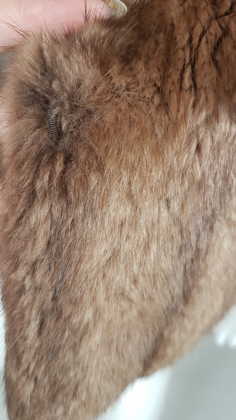Close-up of the concealed metal furrier hook positioned beneath the mink fur along one front edge of the jacket.