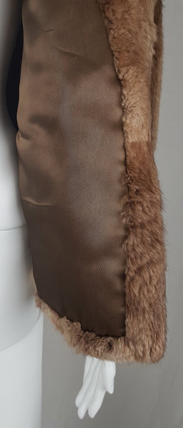 Interior view of the mocha-brown satin lining inside one extended front panel of the mink stole jacket.