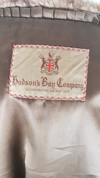 Close-up of the woven 1950s Hudson’s Bay Company label, mocha satin lining and pleated trim inside the vintage mink stole jacket.