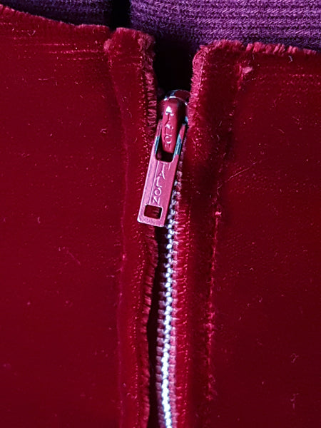 Zipper closeup view of a circa mid-1950s Suzy Perette dark red velvet dress with square neckline, narrow straps and full skirt displayed on a mannequin 
