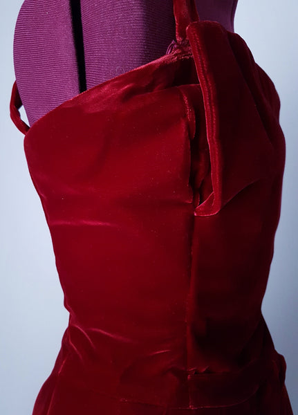 Side bodice view of a circa mid-1950s Suzy Perette dark red velvet dress with square neckline, narrow straps and full skirt displayed on a mannequin 