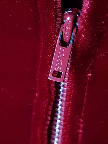 Zipper closeup view of a circa mid-1950s Suzy Perette dark red velvet dress with square neckline, narrow straps and full skirt displayed on a mannequin 