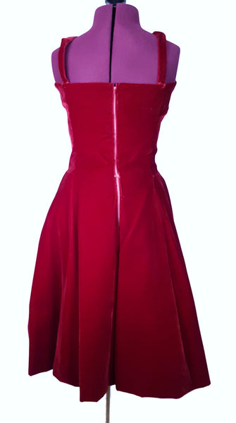 Back view of a circa mid-1950s Suzy Perette dark red velvet dress with fitted bodice, pleated skirt and long velvet waist ties.