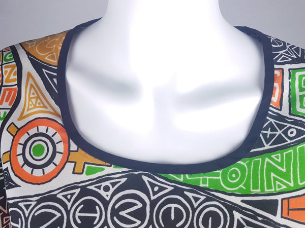 Close-up front shoulder view of a 1960s Gemini zodiac print dress, showing the scoop neckline displayed on a mannequin 