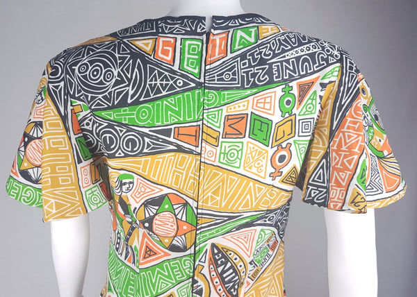 Close-up back shoulder view of a 1960s Gemini zodiac print dress, showing the flared butterfly sleeve, displayed on a mannequin