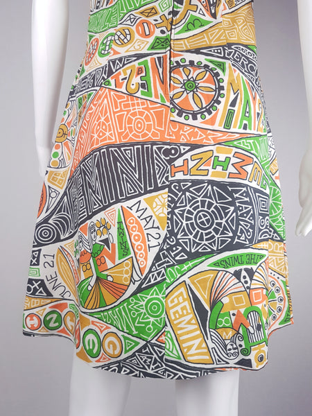 Close-up hemline view of a 1960s Gemini zodiac print dress displayed on a mannequin