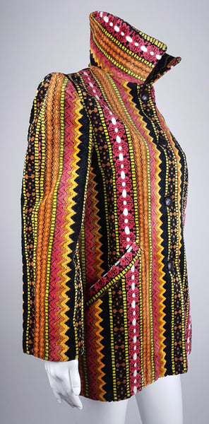 Full three quarter view of a vintage 1960s Trego’s Westwear chenille coat with a raised funnel collar, colourful geometric stripes and angled pockets displayed on a mannequin 