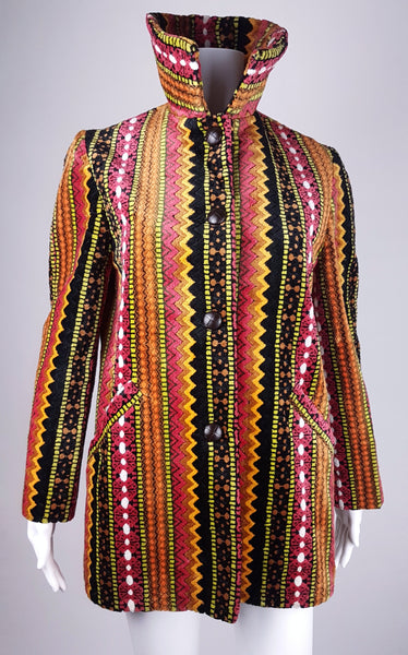 Full front view of a vintage 1960s Trego’s Westwear chenille coat with a raised funnel collar, colourful geometric stripes and angled pockets displayed on a mannequin 