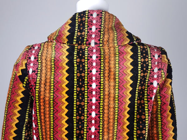 Back shoulder view of a vintage 1960s Trego’s Westwear chenille coat with a folded collar, colourful geometric stripes and angled pockets displayed on a mannequin 