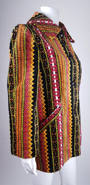 Full three quarter view view of a vintage 1960s Trego’s Westwear chenille coat with a fully buttoned funnel collar, colourful geometric stripes and angled pockets displayed on a mannequin 