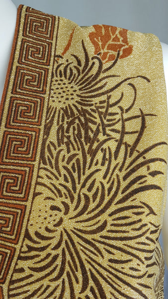 Close-up of the sleeveless V-neckline and chrysanthemum print on a vintage Alfred Shaheen metallic maxi dress.