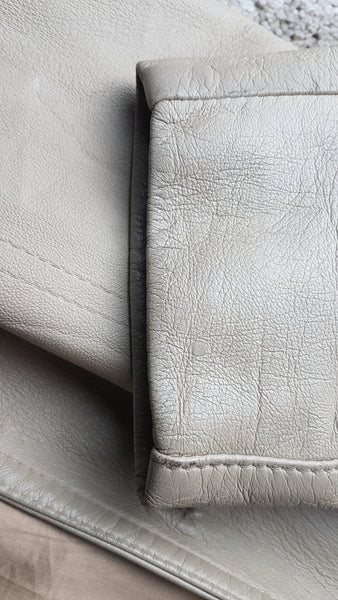 Sleeve hem closeup view of a vintage 1970s sand-coloured leather trench coat 
