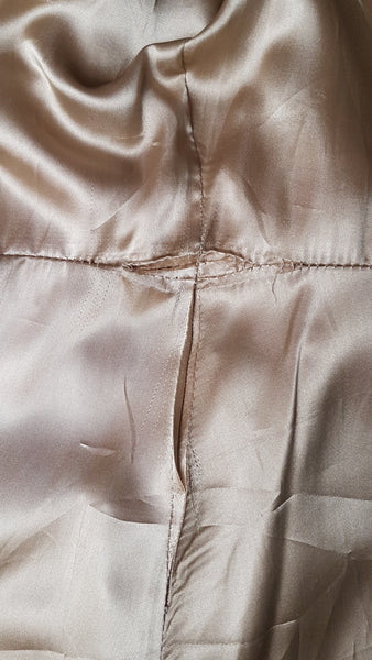 Inner lining view of a vintage 1970s sand-coloured leather trench coat 