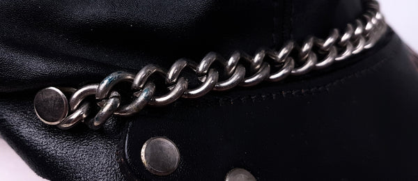 Side close-up showing the silver-tone chain extending around the cap