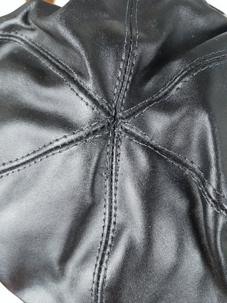 Close-up of the stitched panel seams forming the crown of the black biker cap