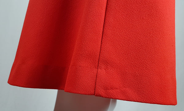 Close up back hemline view of a vintage 1970s Kenny Classics Donnkenny orange-red mod dress  on a mannequin